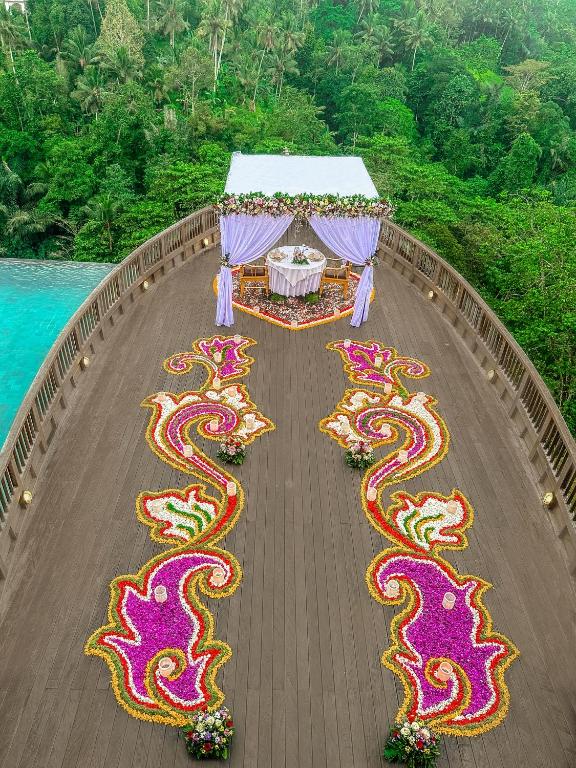 un grupo de serpientes coloridas en un puente de madera en Kastara Resort, en Ubud