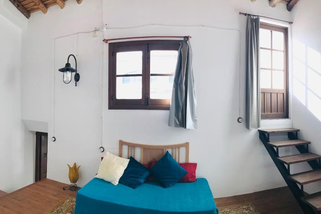 um quarto com uma cama azul e uma janela em Casa Mora em Encinasola