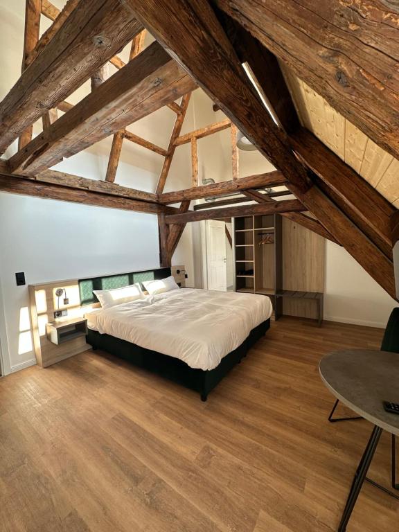 um quarto com uma cama grande num quarto com tectos em madeira em Hopfenhotel am Adenauerufer em Bamberg