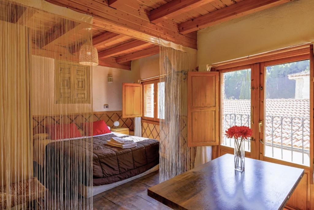 a bedroom with a bed and a table and a window at Casita de Noah in Arnedillo