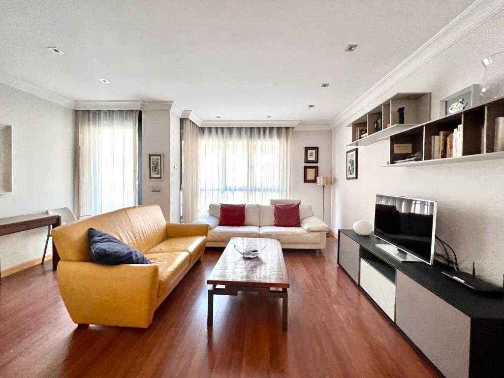 uma sala de estar com um sofá e uma mesa em Housingleón - Centro Colón em León