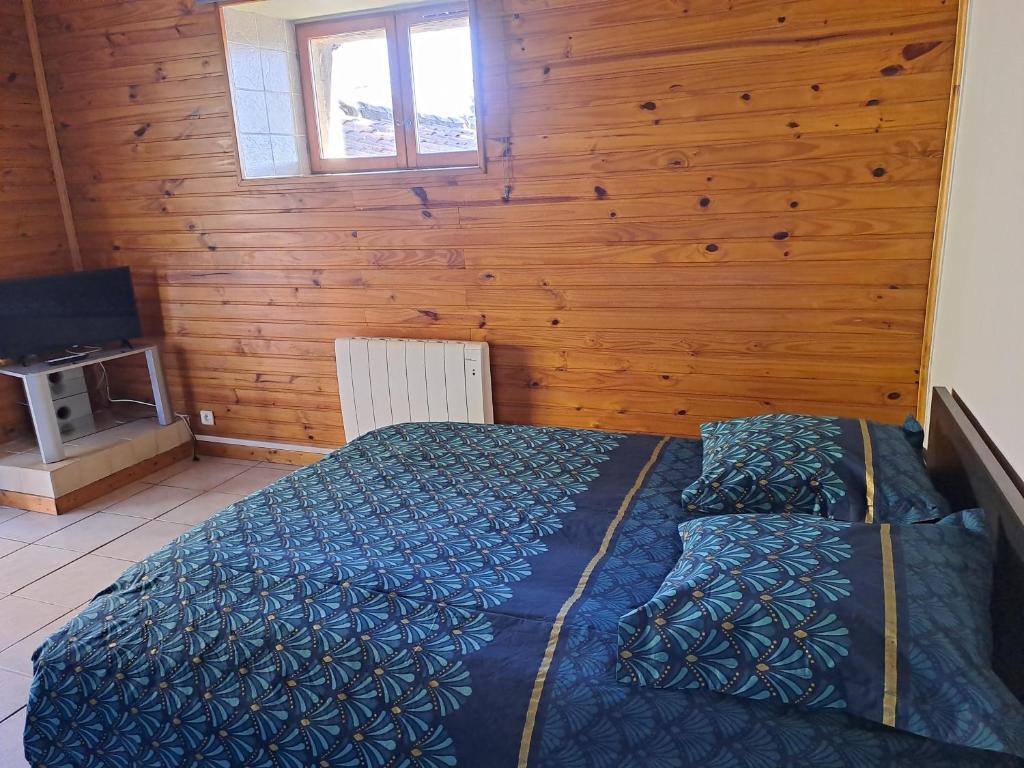 - une chambre avec un lit et un mur en bois dans l'établissement Gîte "LE LAURUS" aux Magnolias, à Aubenas