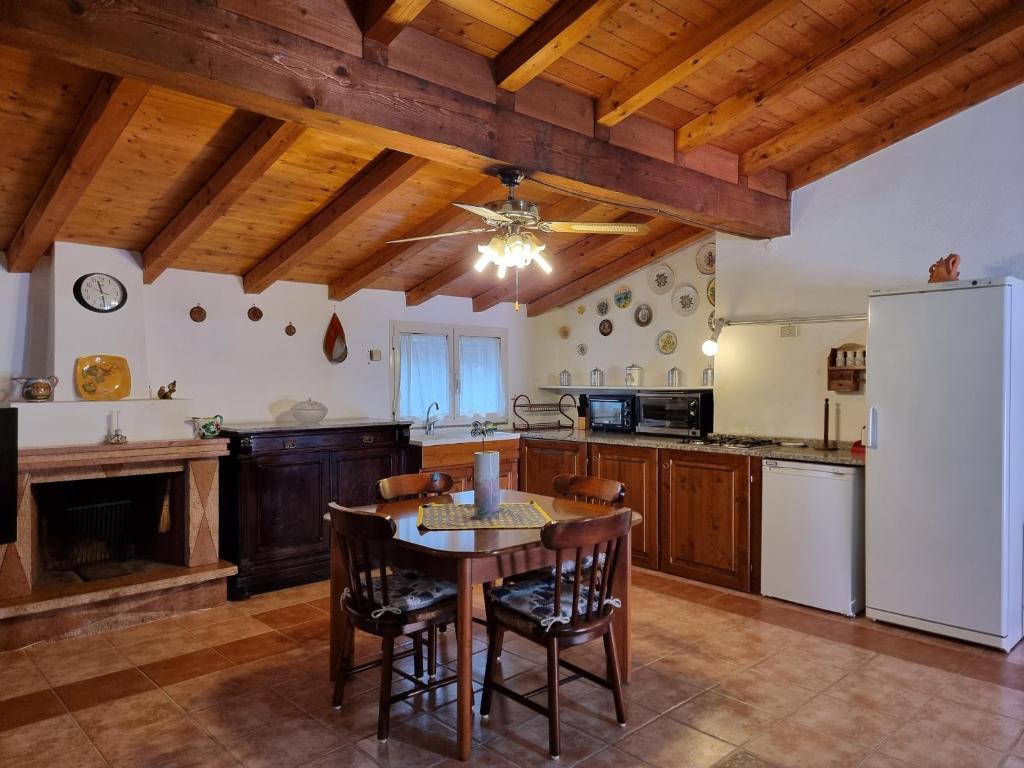 a kitchen with a table and a white refrigerator at Villa Monte Rena in Budoni