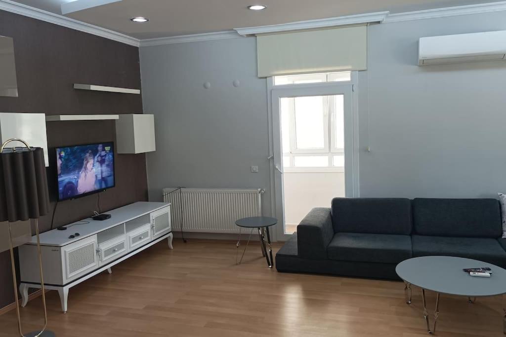 sala de estar con sofá y TV en 3 rooms and living room, centrally located, large apartment, en Bayrakli