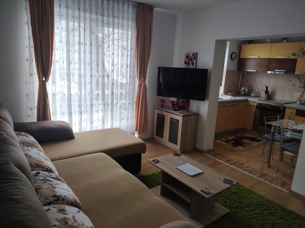 een woonkamer met een bank en een tafel en een keuken bij Avantgarden1 .Apartament lux in Braşov