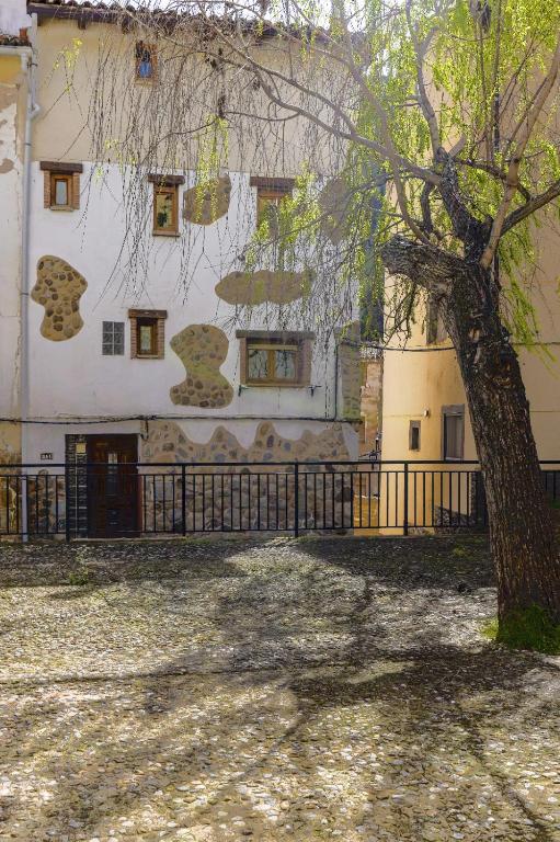 a building with a tree in front of it at Casita de Orlando by Apartamentos Arnedillo in Arnedillo
