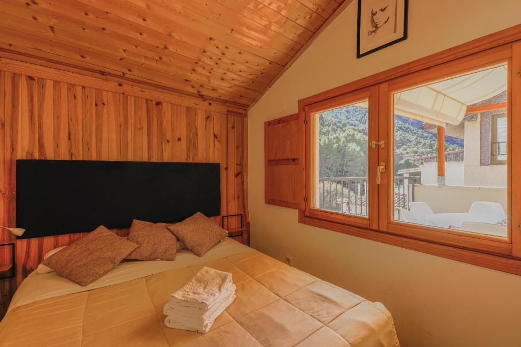 a bedroom with a bed with a large window at Casita de Orlando in Arnedillo