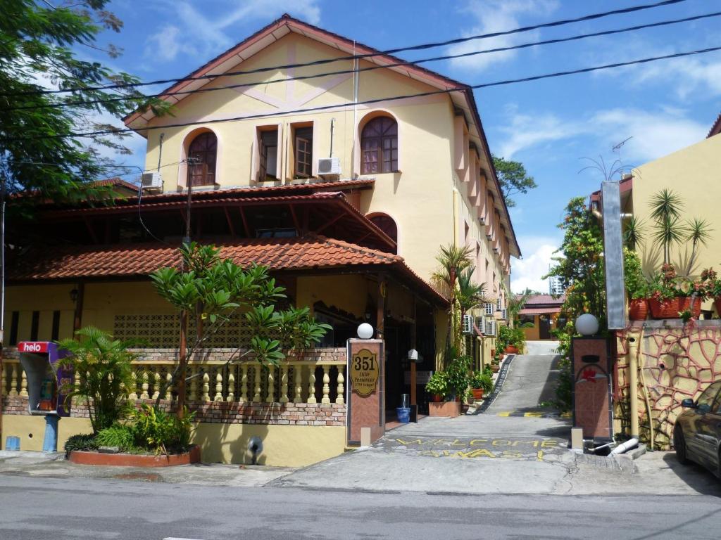 una casa amarilla con una valla delante de ella en Anggerik Lodging, en George Town