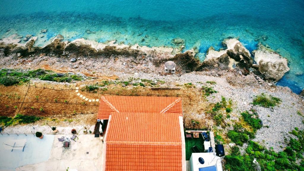 an aerial view of a beach with the ocean at Tholos Alexandra's Beachfront House in Kavoúsion