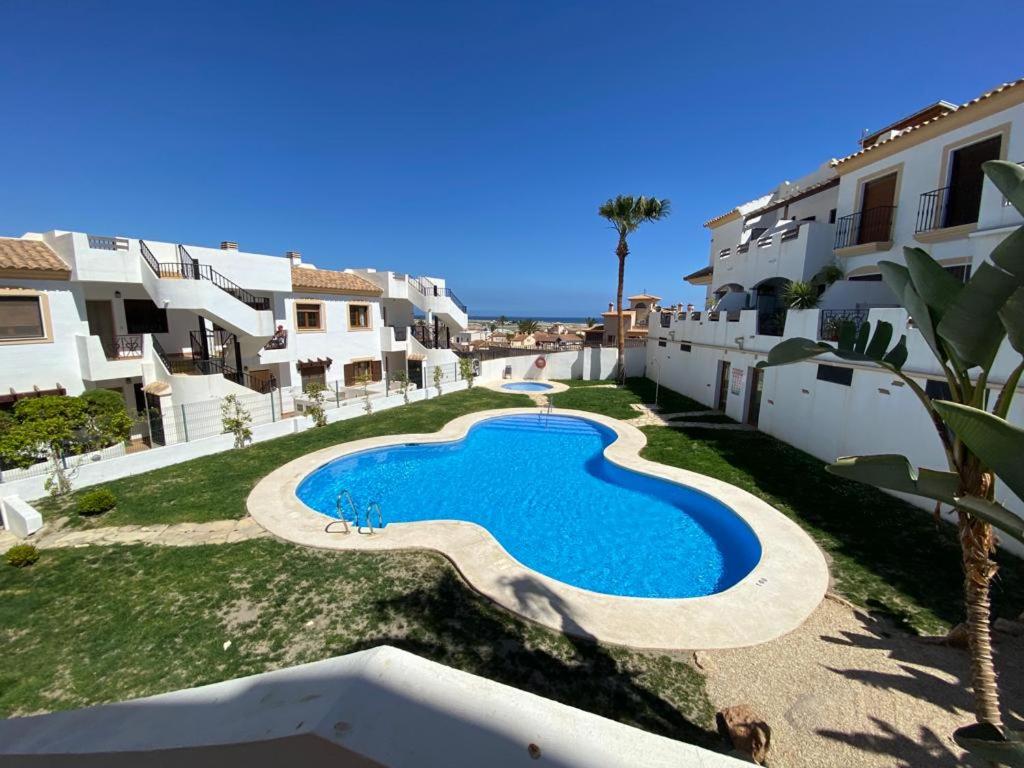 una piscina en un patio junto a algunos edificios en Apartamento en la costa de Almería ( Palomares ) en Palomares