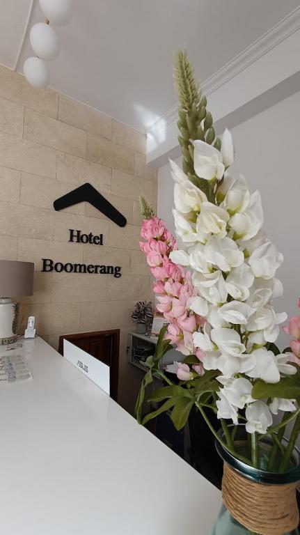 a vase filled with white and pink flowers on a counter at Hotel Boomerang in Valverde