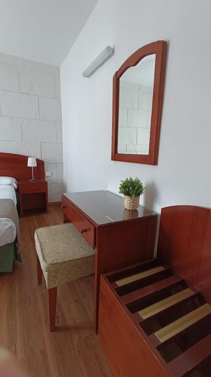 a bedroom with a desk with a mirror and a bed at Hotel Boomerang in Valverde