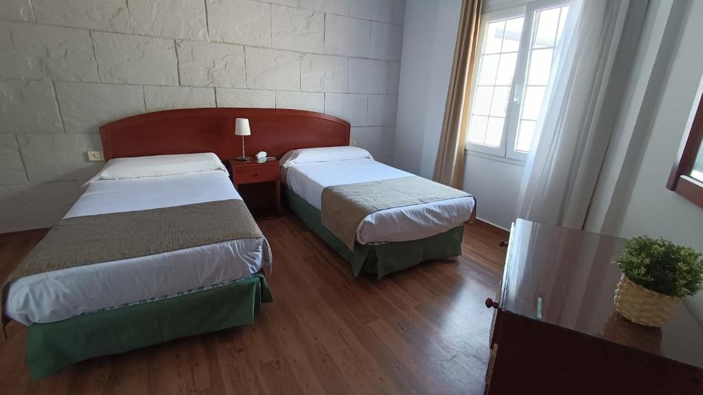 a hotel room with two beds and a window at Hotel Boomerang in Valverde