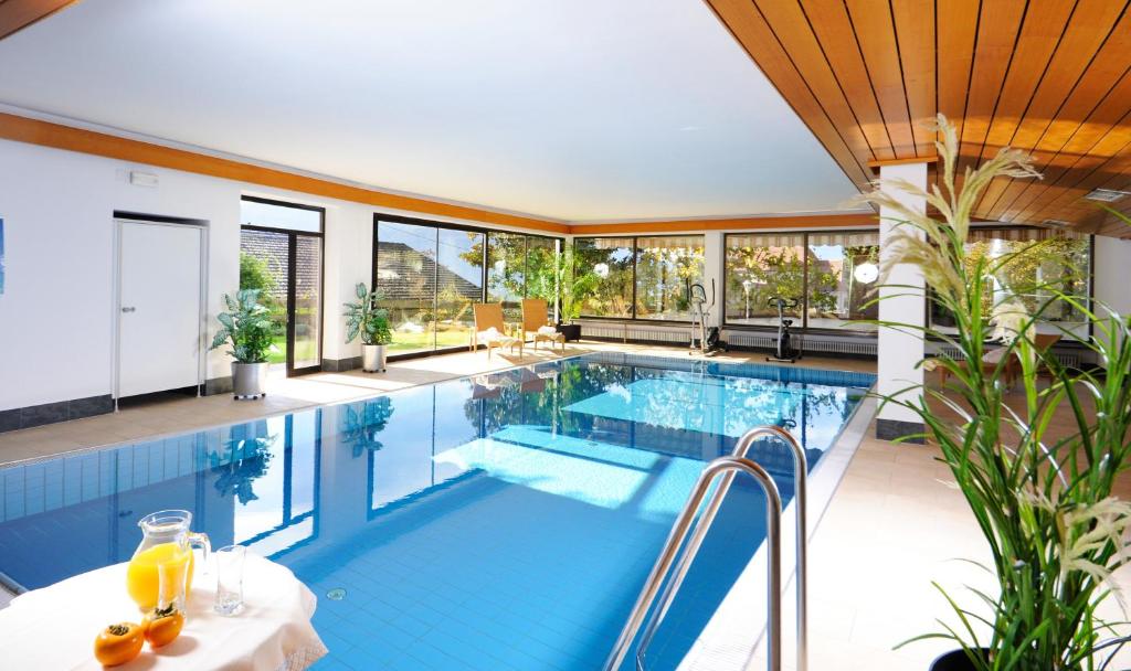 an indoor swimming pool with a large glass wall at Frühstückspension Appartement Südtirolerhof in Schenna