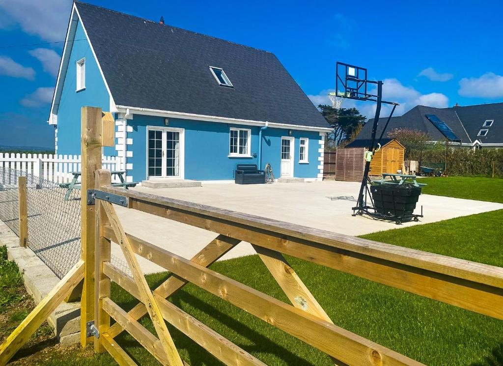 una casa azul con una valla de madera delante de ella en Hilltop Haven Kilmore en Kilmore