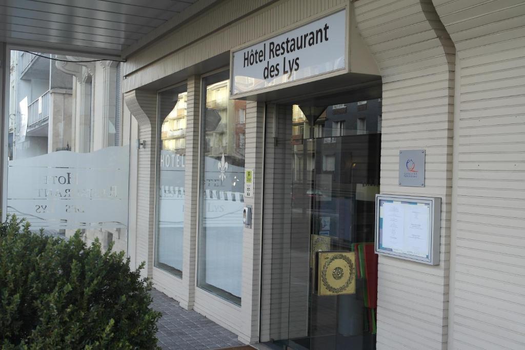 Przednia część sklepu z napisem, który czyta, że spotykają się psy respondentów żyje w obiekcie Hôtel Restaurant Des Lys w mieście Le Coteau