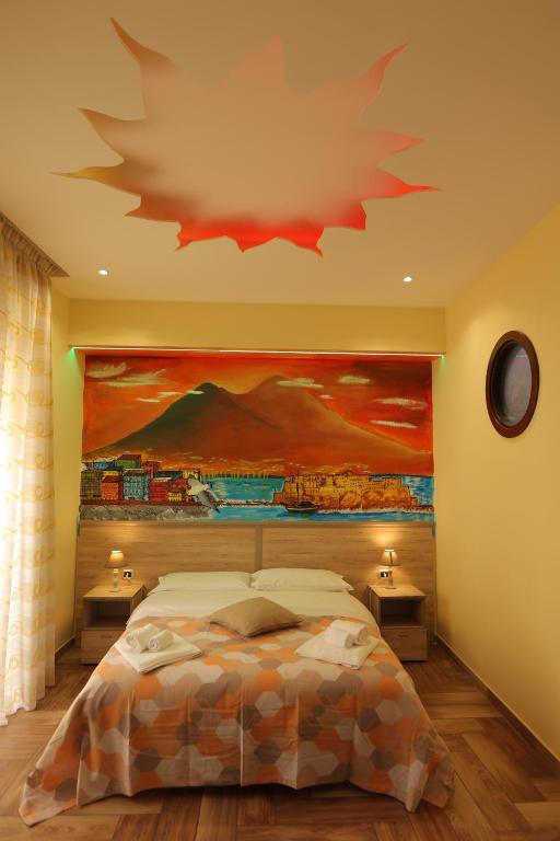 - une chambre avec un grand tableau au-dessus d'un lit dans l'établissement L'Ammor e Napule, à Naples