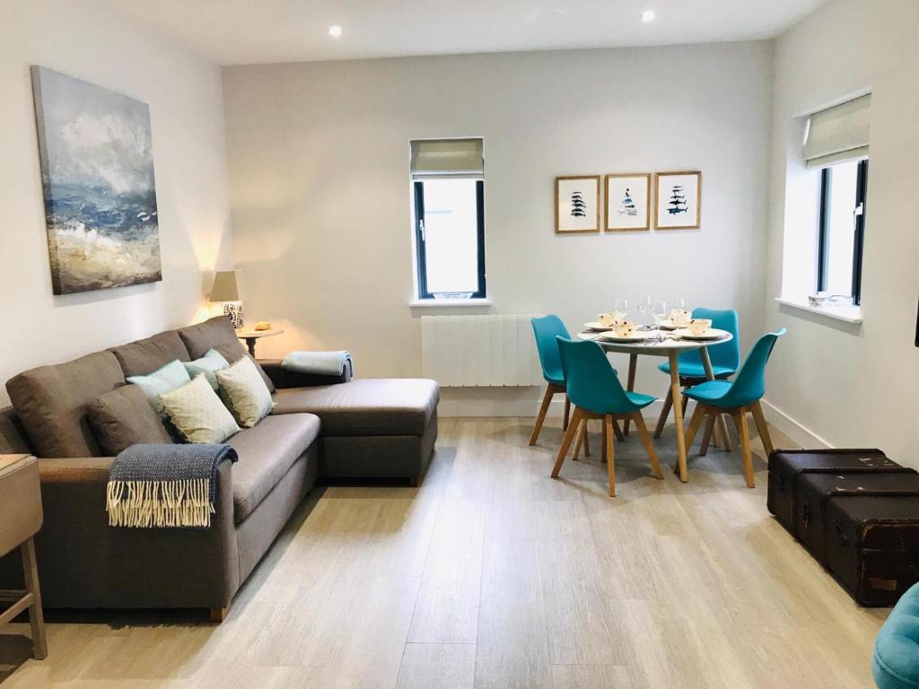 a living room with a couch and a table at 5 Rockham - Luxury Apartment at Byron Woolacombe, only 4 minute walk to Woolacombe Beach! in Woolacombe