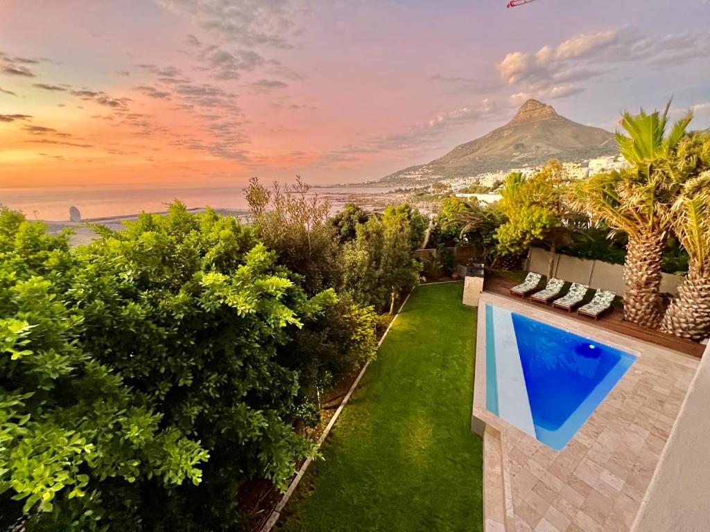 a backyard with a view of the ocean and a mountain at One On Houghton in Cape Town