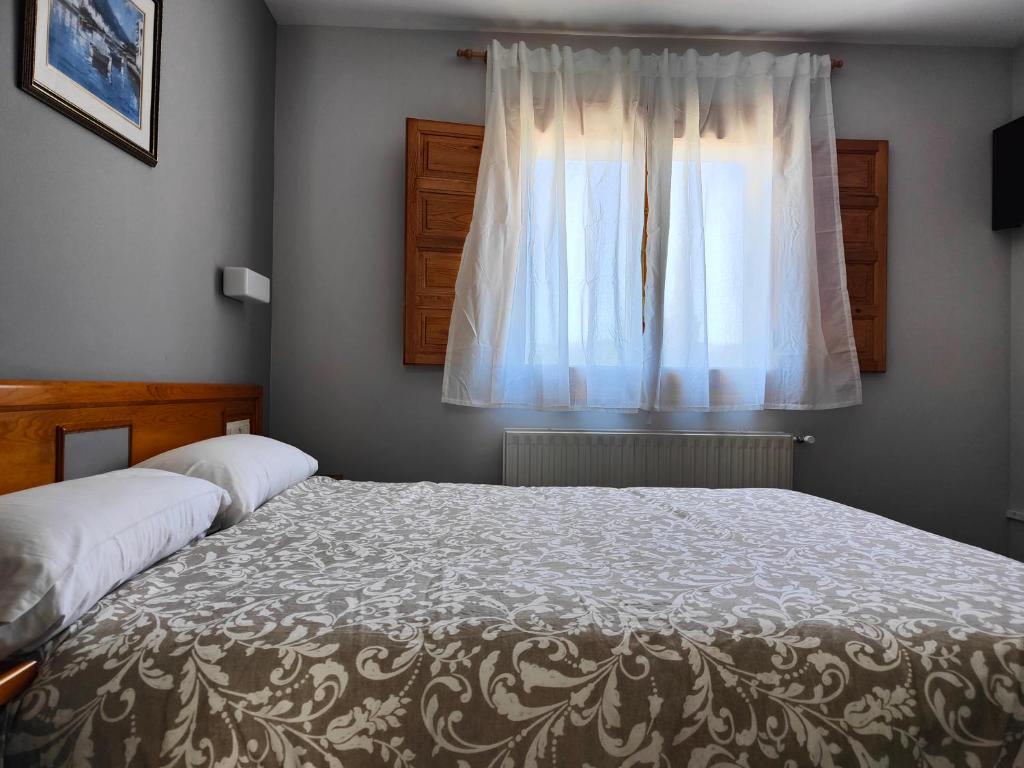 A bed or beds in a room at Hotel Puerta de Javalambre