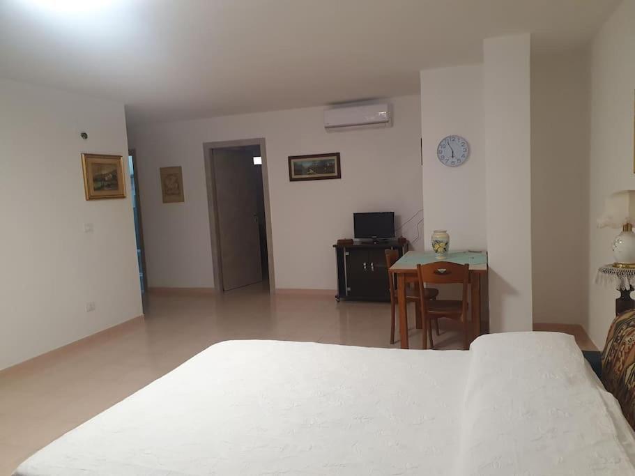 een slaapkamer met een bed, een tafel en een bureau bij casa vacanza Nonna Lina in Rosolini