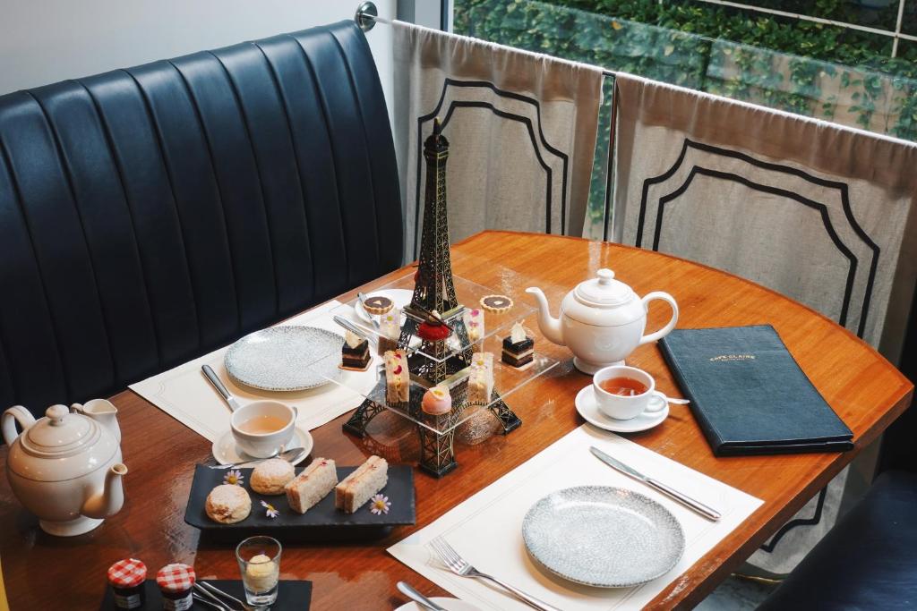 A two-person tea service arranged on a wooden table beside a window.