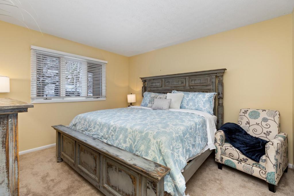a bedroom with a large bed and a chair at Cozy fireplace home at Wintergreen all amenities in Lyndhurst