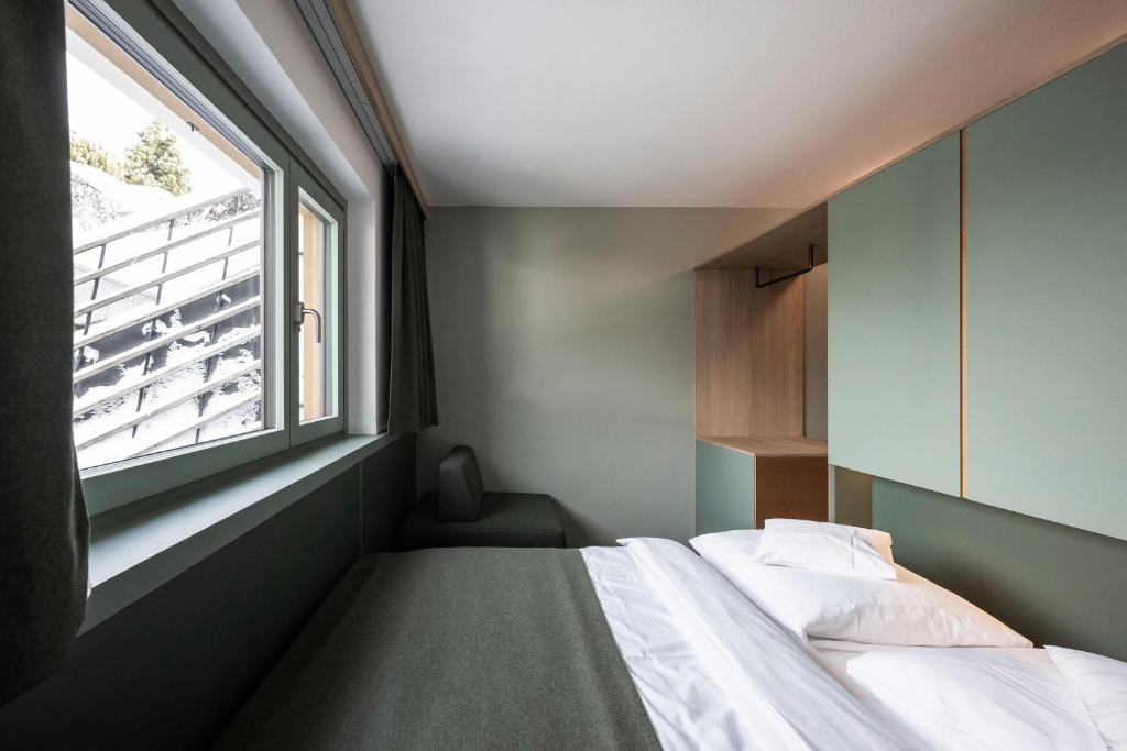 Łóżko lub łóżka w pokoju w obiekcie Paramount Alma Suites Sexten