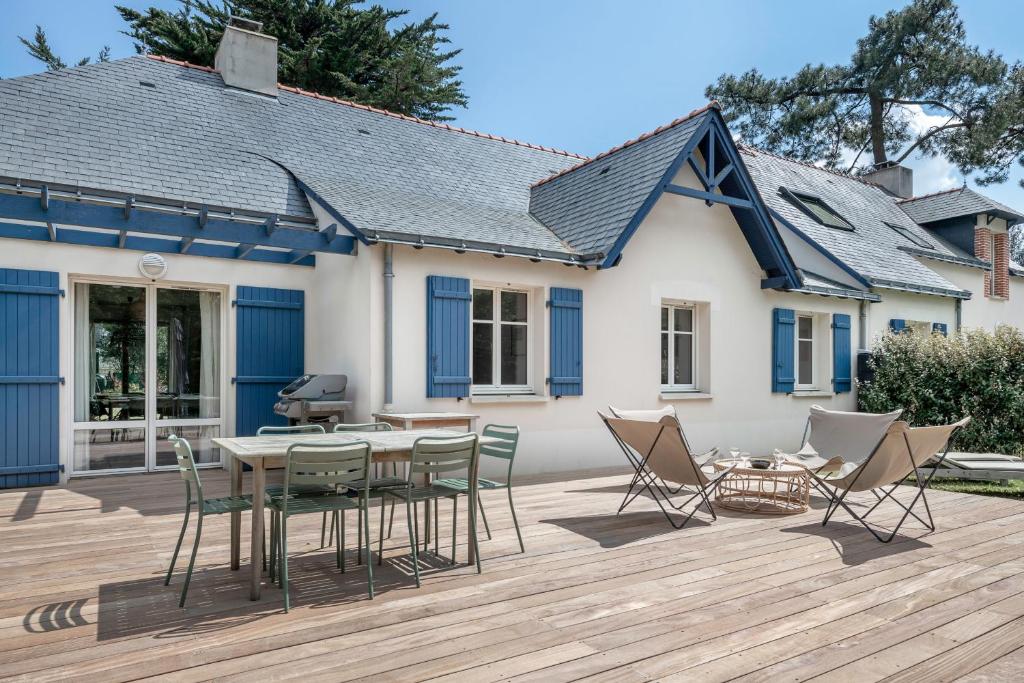 un patio avec des chaises et une table et une maison dans l'établissement Charmante villa tout confort et à 500m de la plage, à Pornichet