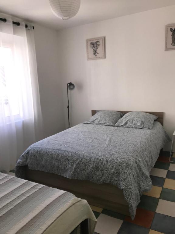 een slaapkamer met een bed en een raam bij la Porte bleue in Capestang