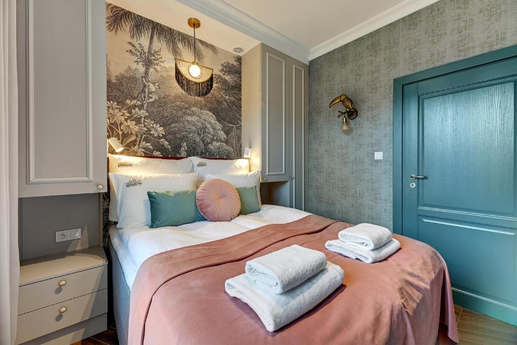 Un dormitorio con una cama grande con toallas. en Ogarna Baltus, Main Old Town by Downtown Apartments, en Gdansk