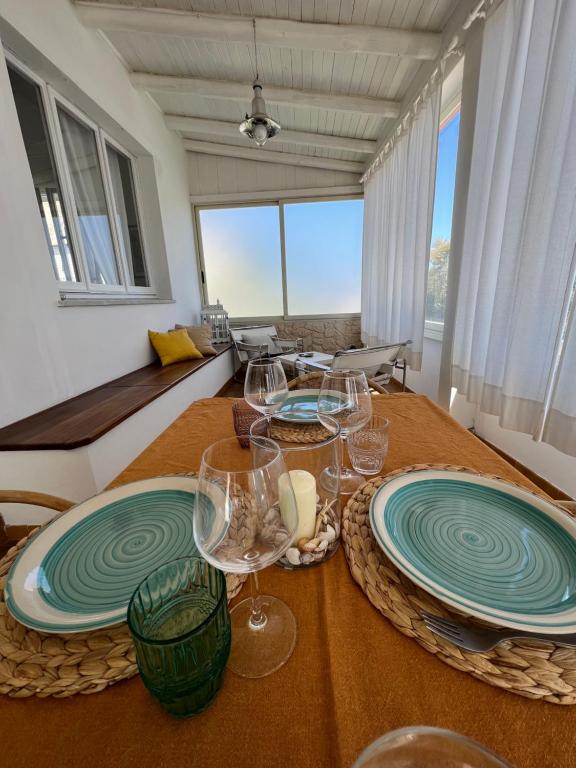 una sala da pranzo con due tavoli con piatti e bicchieri da vino di Da u Franchin a Carloforte