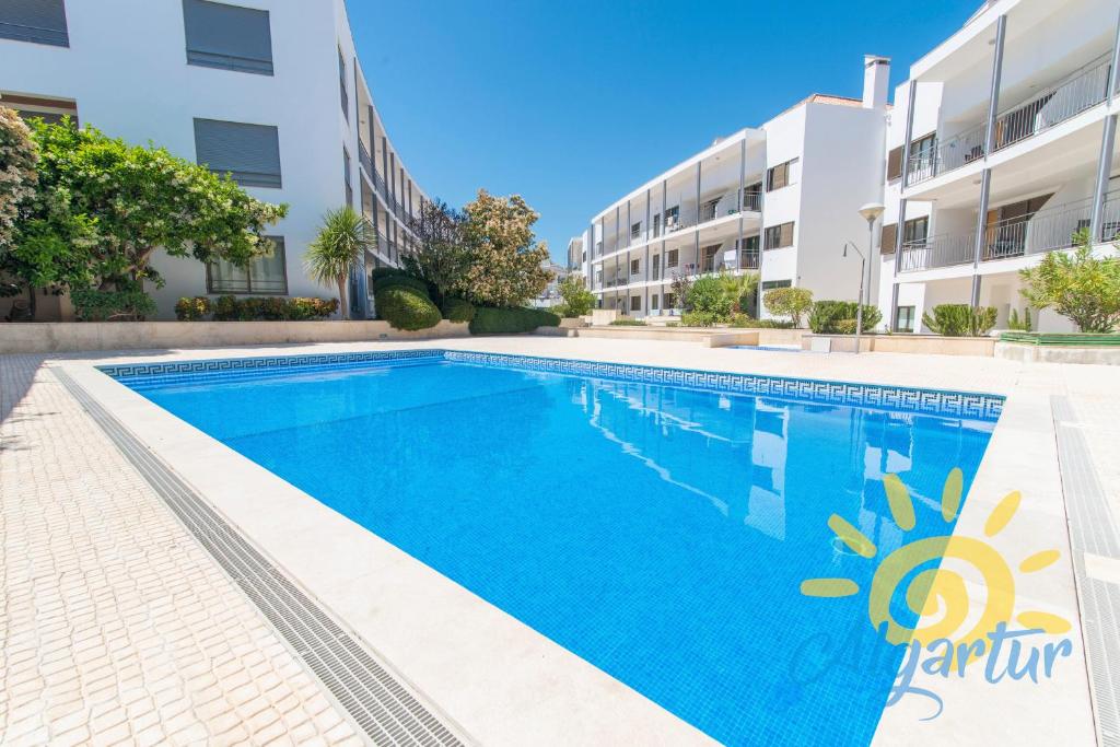 a swimming pool in front of a building at Poço do Bispo By ALGARTUR in Tavira