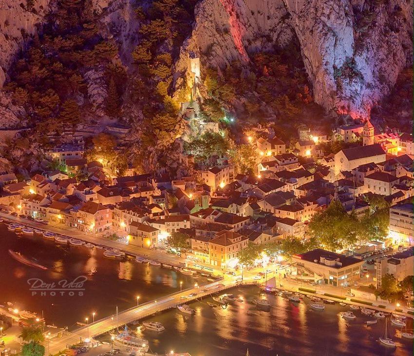 a city lit up at night with a mountain at Apartmani Jelena in Omiš