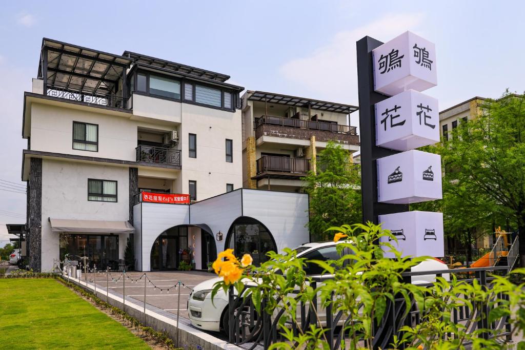 un coche blanco estacionado frente a un edificio en 鴝花甜點民宿 QuHua Sweety B&B, en Dongshan