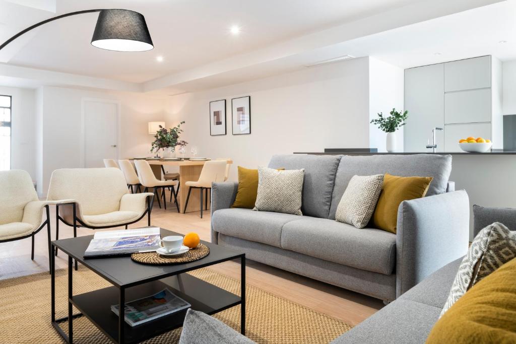 ein Wohnzimmer mit einem Sofa und einem Tisch in der Unterkunft Magno Apartments Castelar in Sevilla