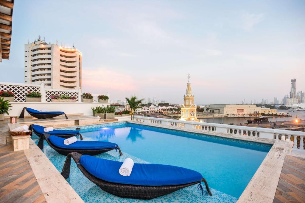 una piscina en la azotea de un edificio con tumbonas en NH Royal Urban Cartagena, en Cartagena de Indias