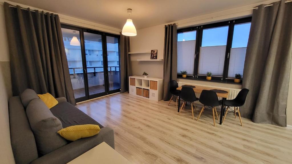 a living room with a couch and a table with chairs at Apartament Czerwone Maki in Krakow