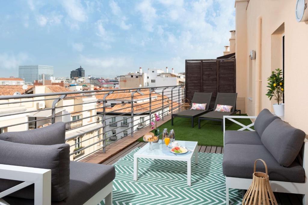 a balcony with chairs and a table on a roof at NH Madrid Lagasca in Madrid