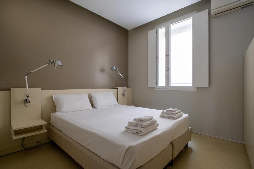 - une chambre avec un lit blanc et des serviettes dans l'établissement Residence i MasCa', à Bologne