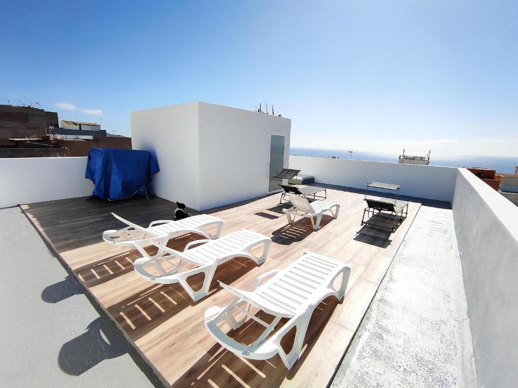 a deck with white chairs and tables on a roof at Villa Ocean View - Costa Adeje - Near Golf - Tenerife South - Canary Islands - Spain in Armeñime