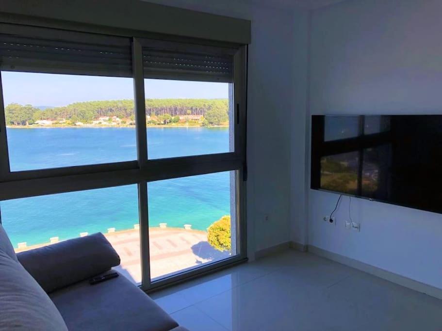 una sala de estar con vistas a un cuerpo de agua en El Capricho de la ría II en O Grove