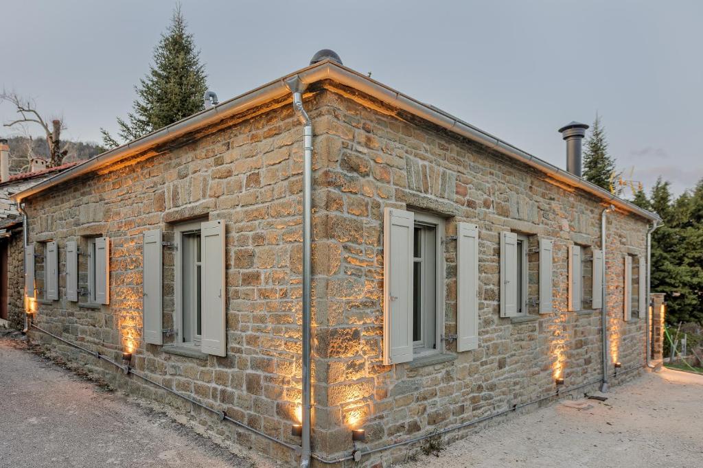 a brick building with windows and lights on it at LozArt Traditional Stone House in Ellinikón
