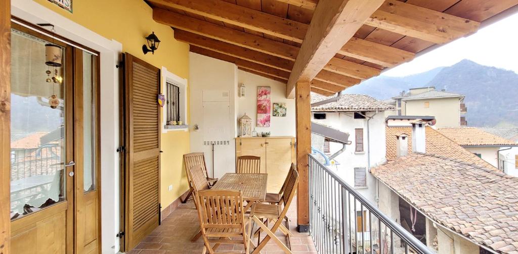 un balcón con mesa y sillas. en Attic family apartment in center of Moggio en Moggio