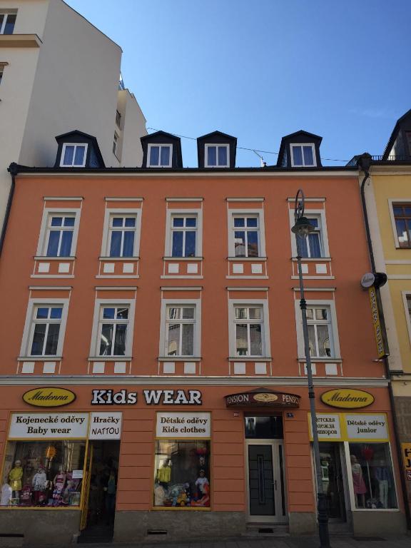 a large orange building with windows on a street at Pension Dvořák in Karlovy Vary