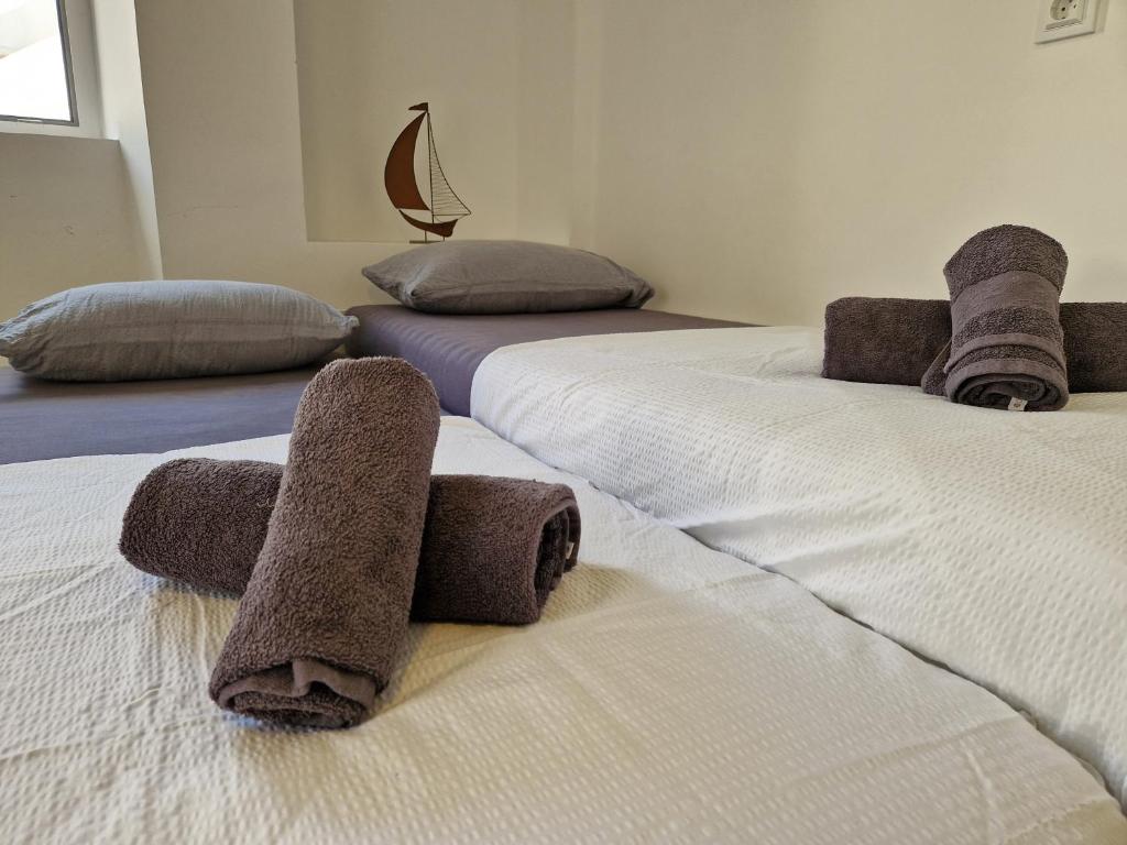 two beds with towels on them in a room at Ricky Apartments in Novalja