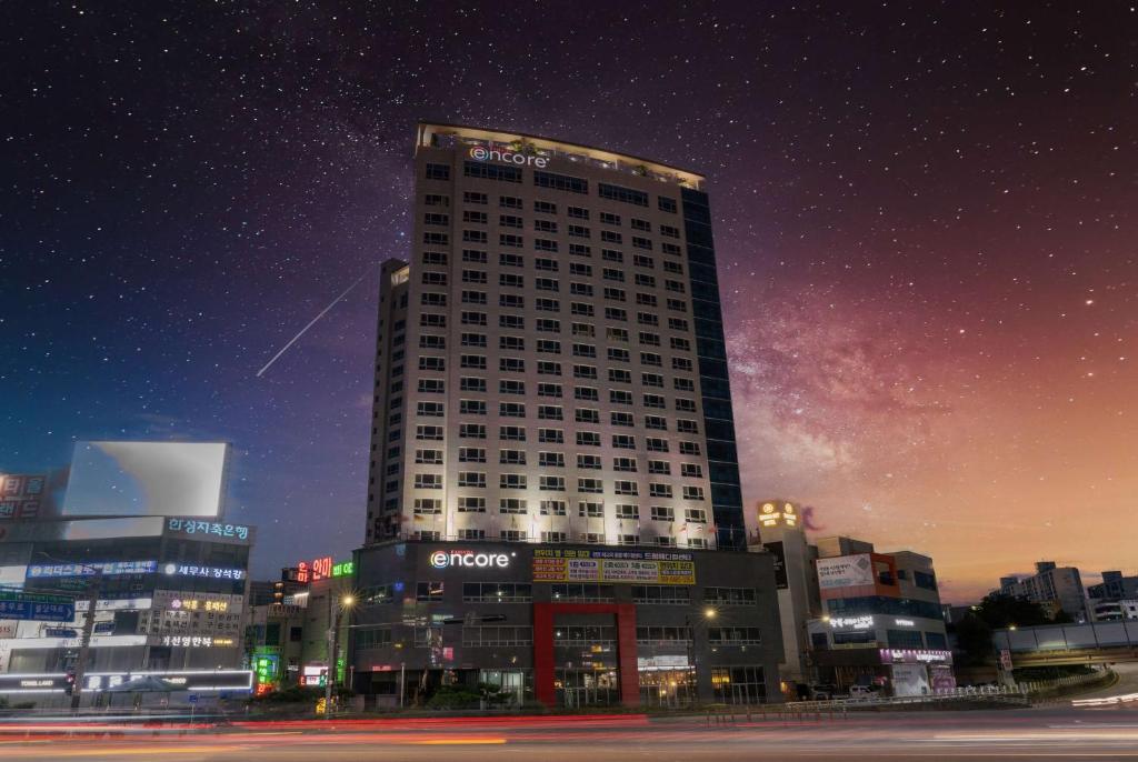 um edifício alto numa cidade à noite em Ramada Encore by Wyndham CheonAn em Cheonan