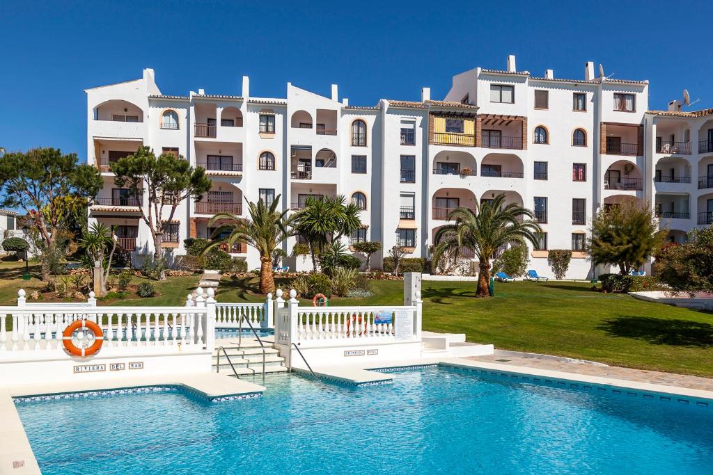 um grande edifício branco com uma piscina em frente a um edifício em Riviera del Mar apartment em Mijas Costa