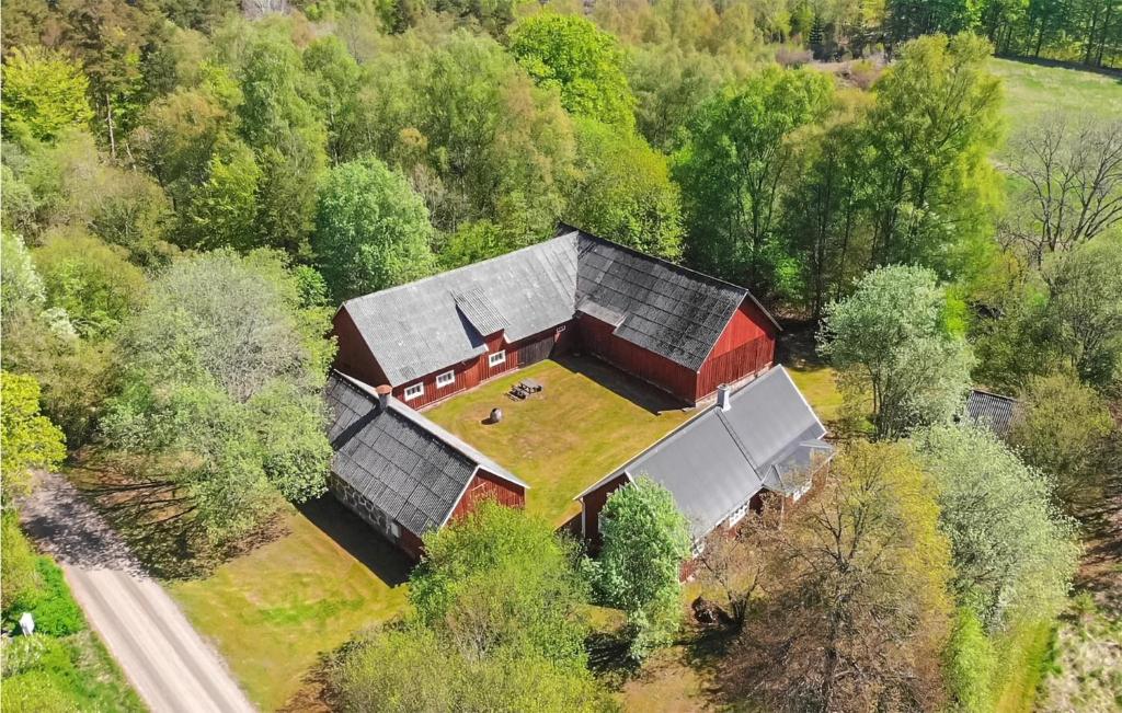 an aerial view of a barn in the middle of a forest at Cozy Home In Hishult With Kitchen in Knäred
