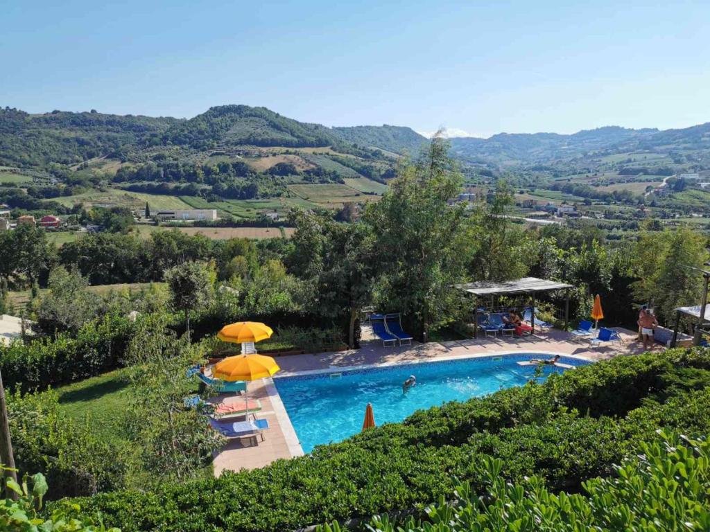 a swimming pool with umbrellas and chairs and a pool at Il Girasole Country Village in Massignano